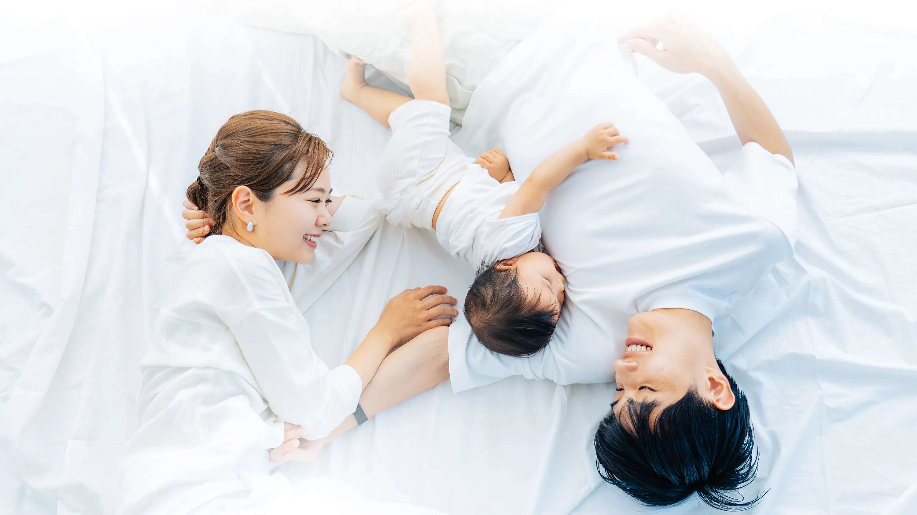 Photo:Young couple with baby lying