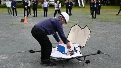 A team member carefully loads pharmaceutical supplies onto the drone.